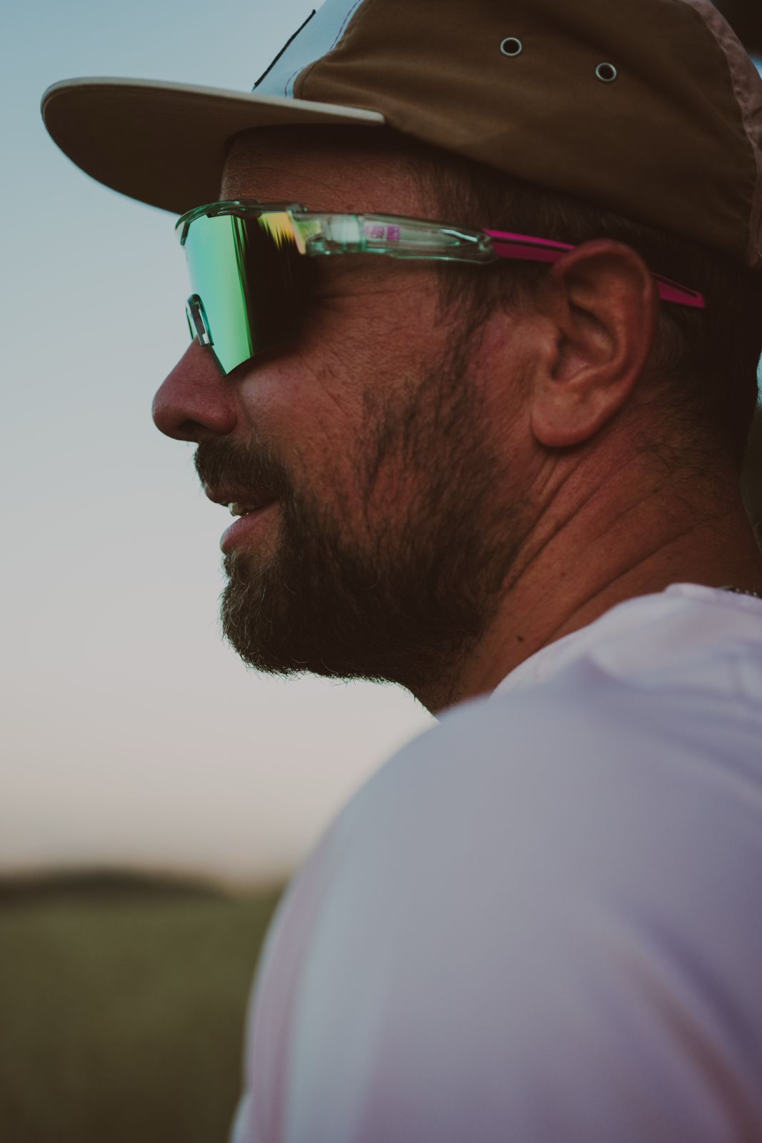 Coureur avec casquette et lunettes trail au coucher du soleil